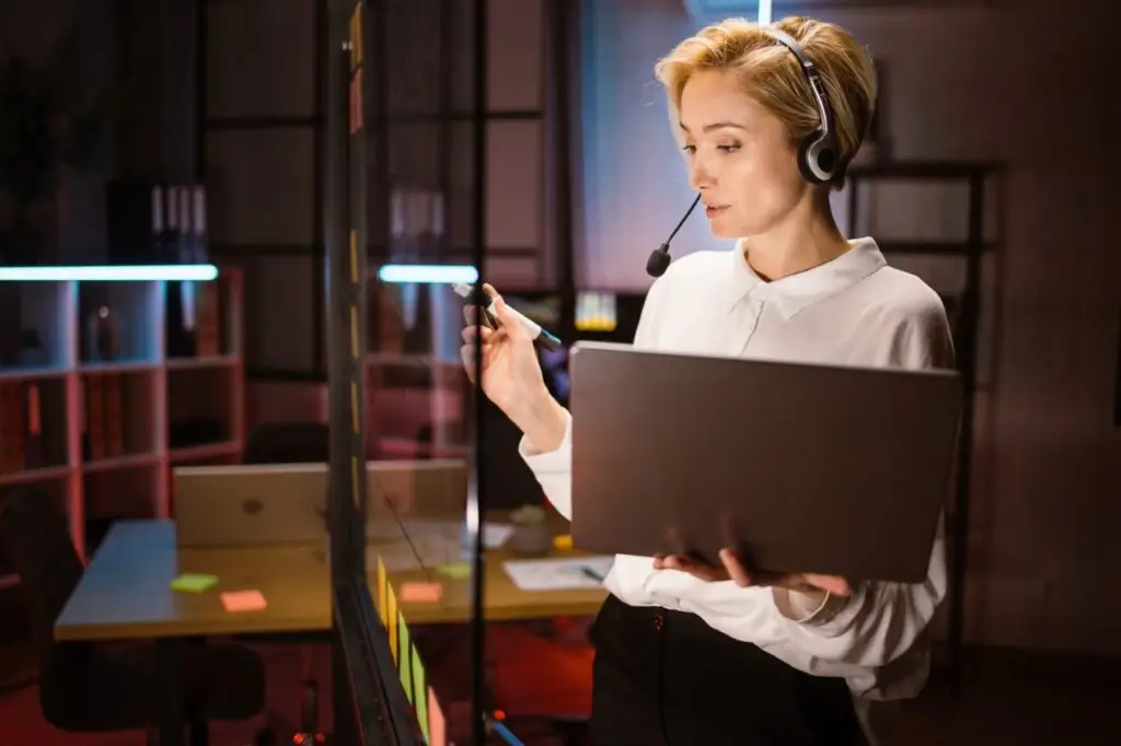 female-worker-wearing-headset-and-using-laptop