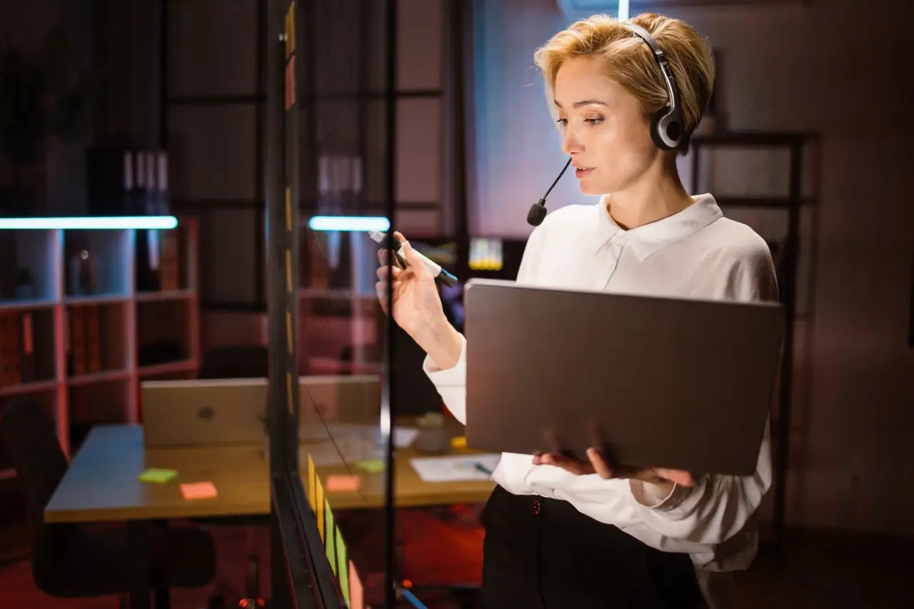 female-worker-wearing-headset-and-using-laptop